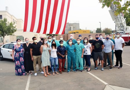 Members of the Air Force medical team say goodbye as they pose in front of a large American flag Friday morning.